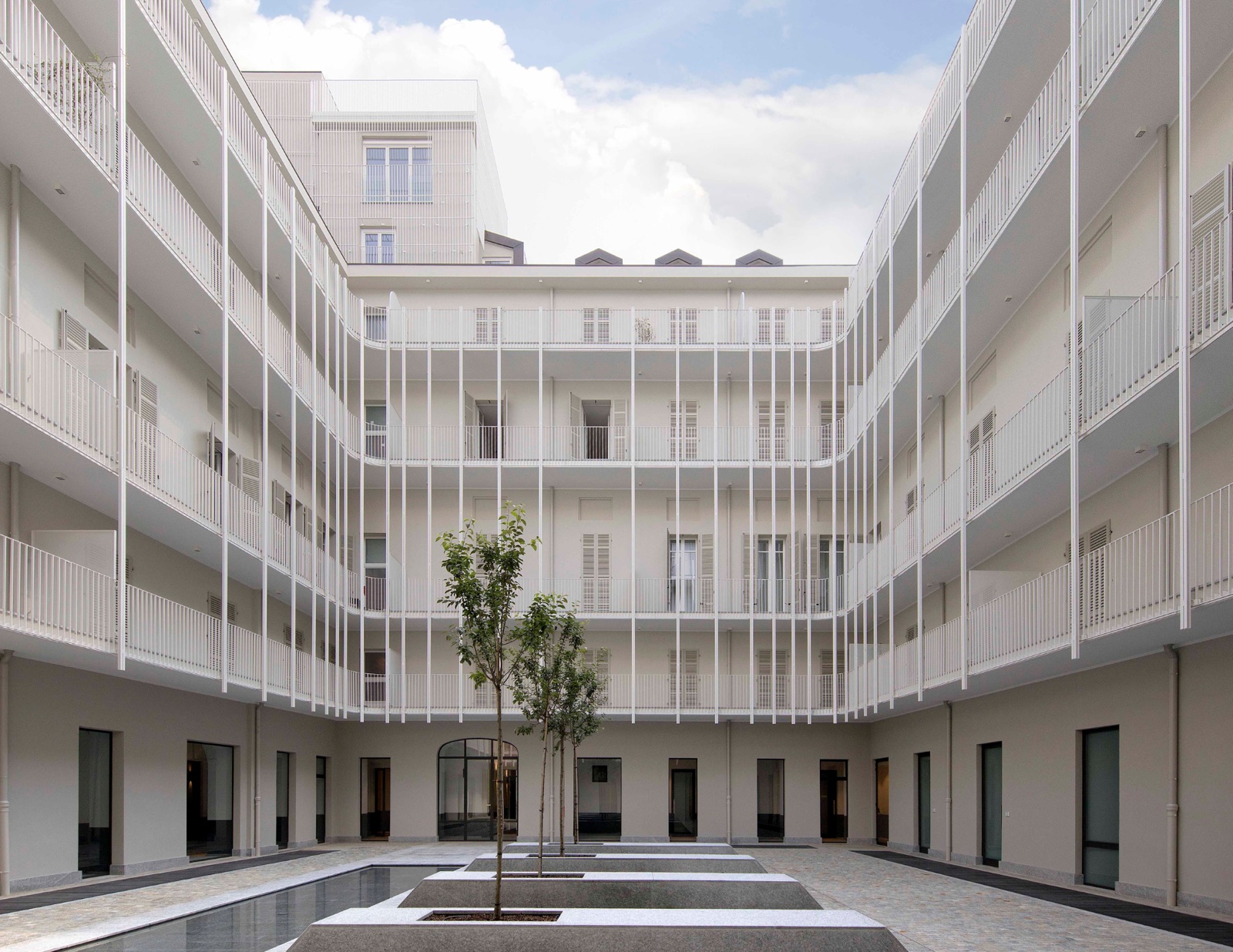 Corte interna riqualificata con ballatoi bianchi — progetto dello studio