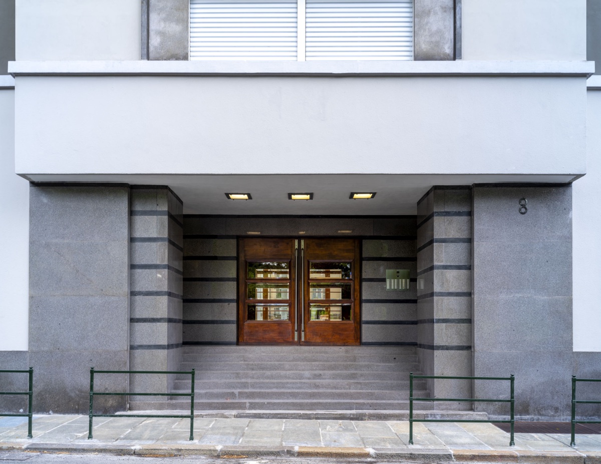 Ingresso razionalista in granito con portoni in legno — progetto dello studio